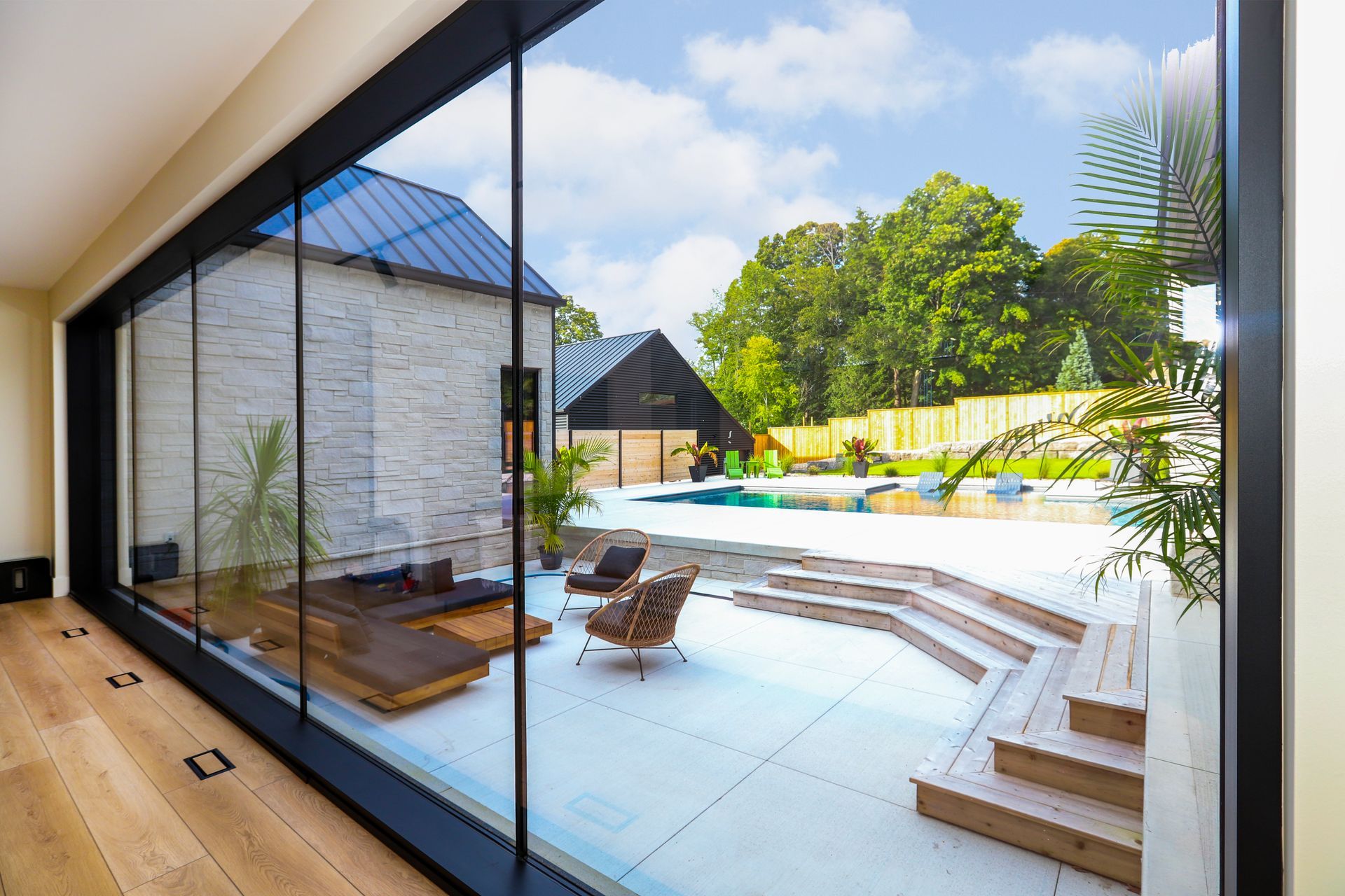 A large window with a view of a patio and a pool.