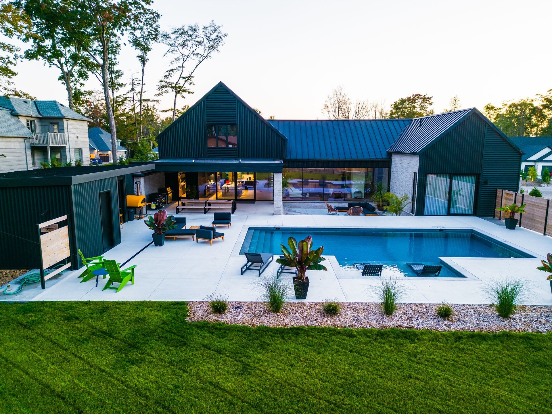 An aerial view of a house with a large swimming pool in the backyard.