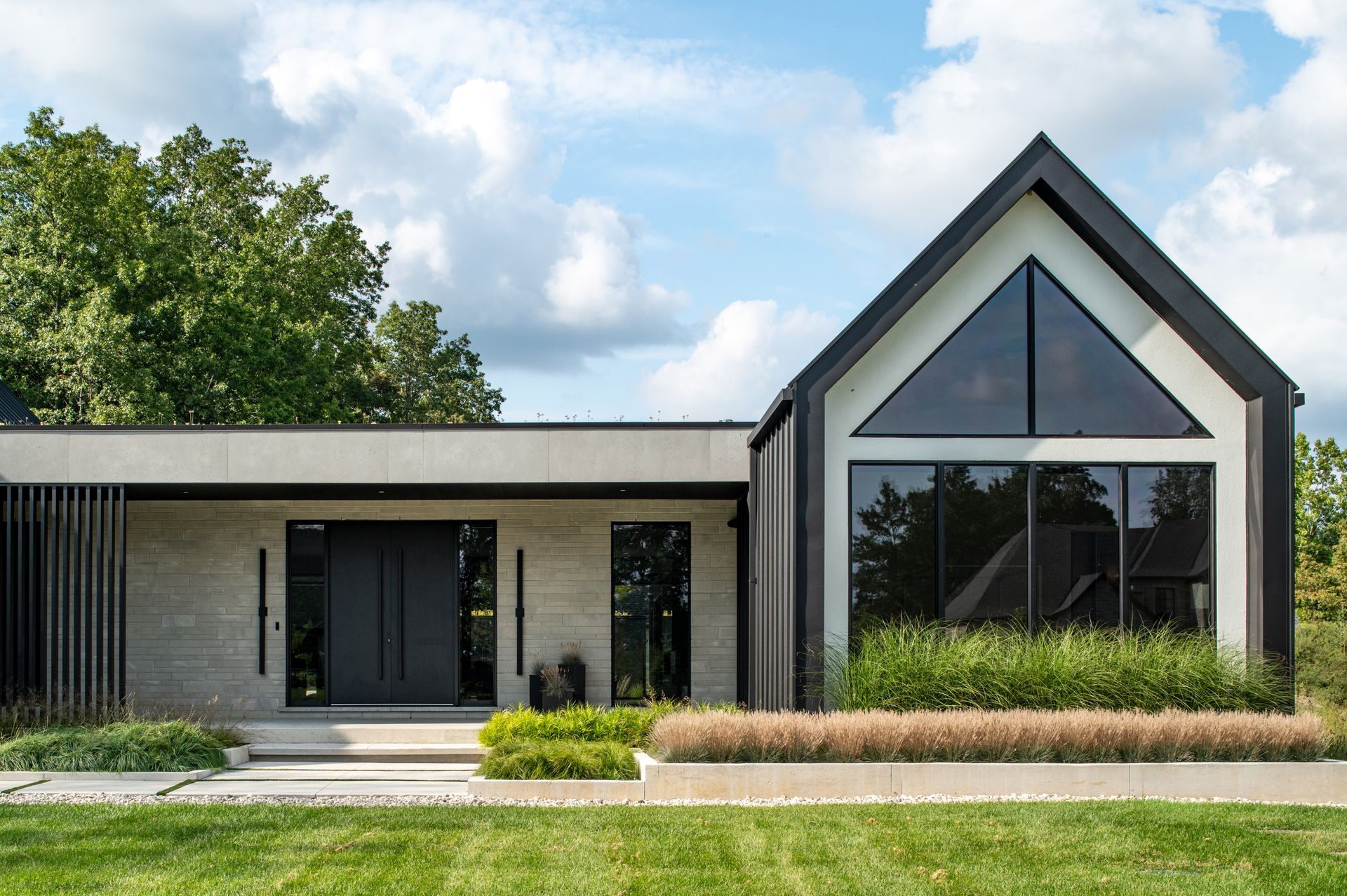 A white and black house with a triangle roof