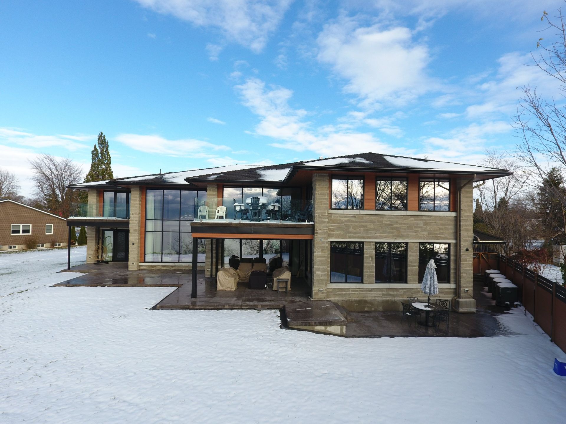 A large house with a lot of windows is covered in snow.