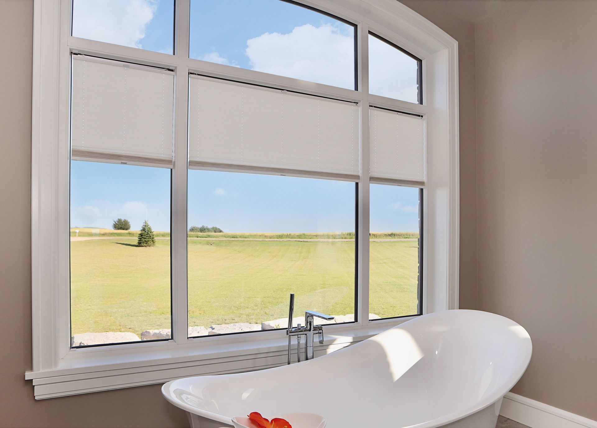 A bathroom with a bathtub and a large window