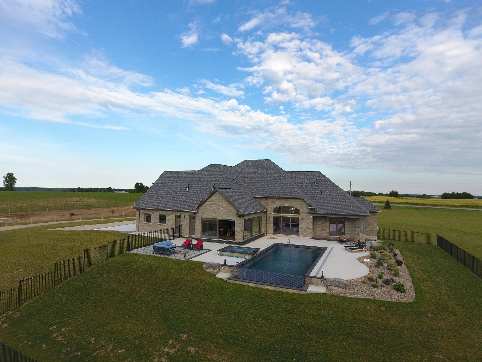An aerial view of a house with a large pool in the backyard.