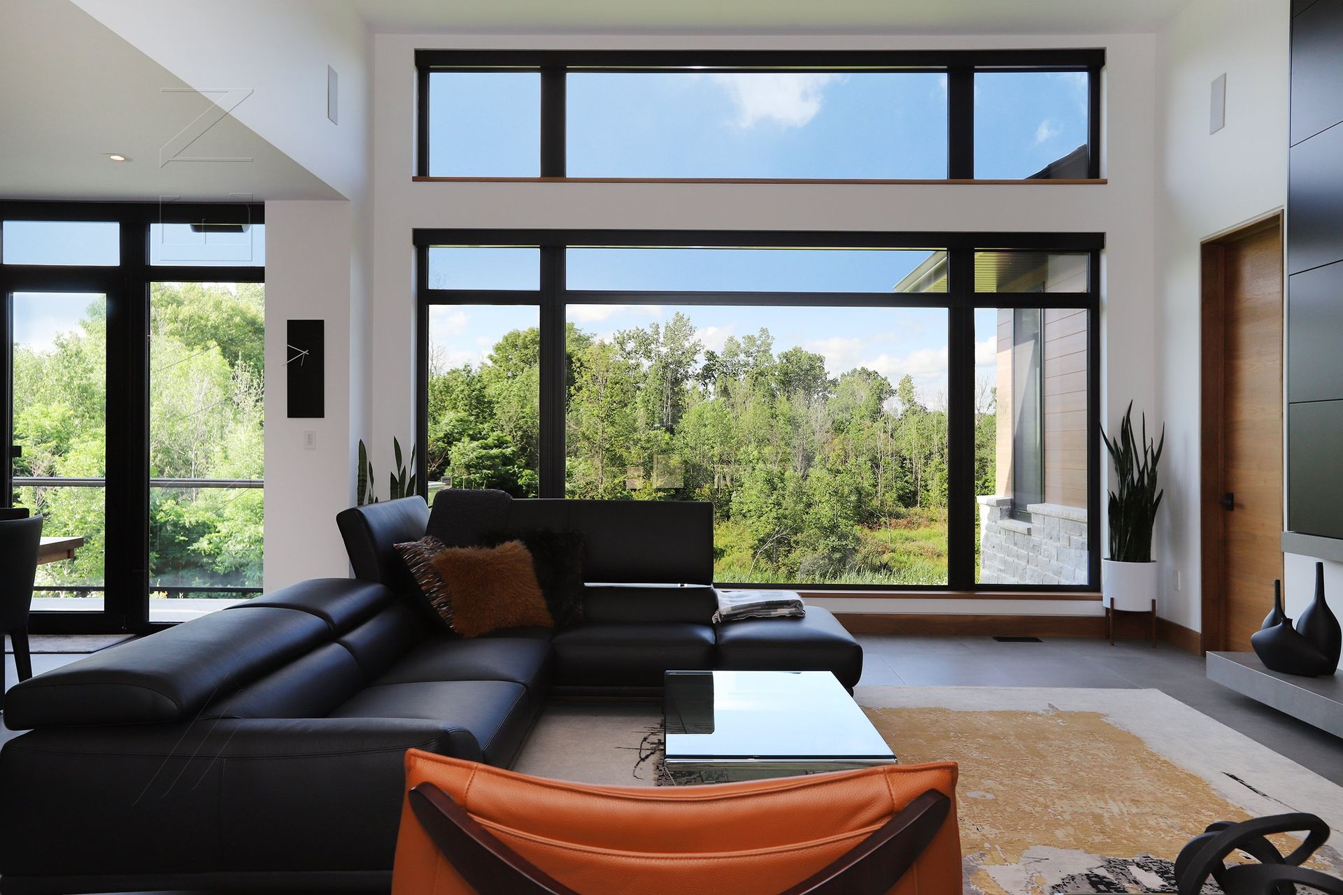 A living room with a black couch and a large window