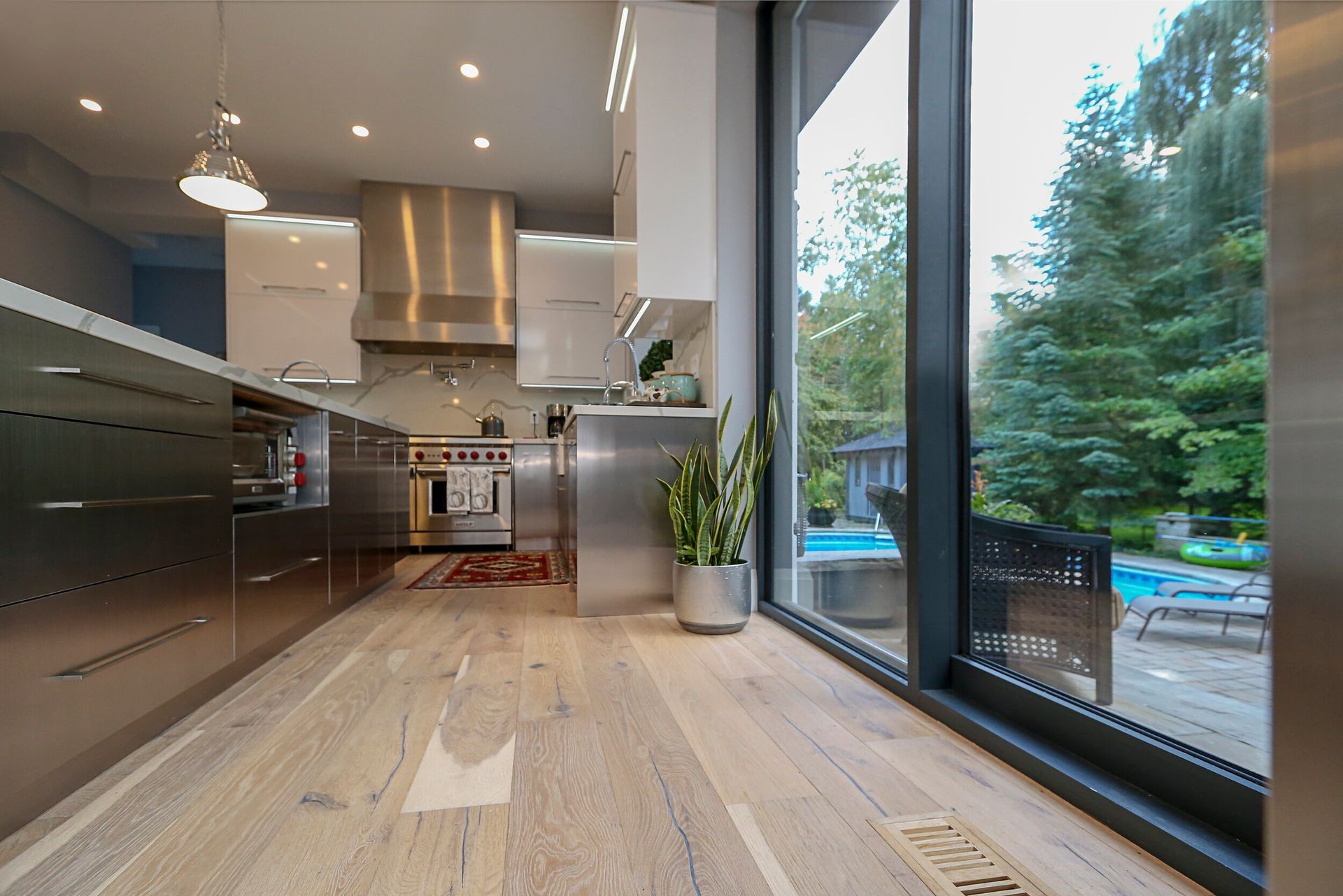 A kitchen with stainless steel appliances and a large window.