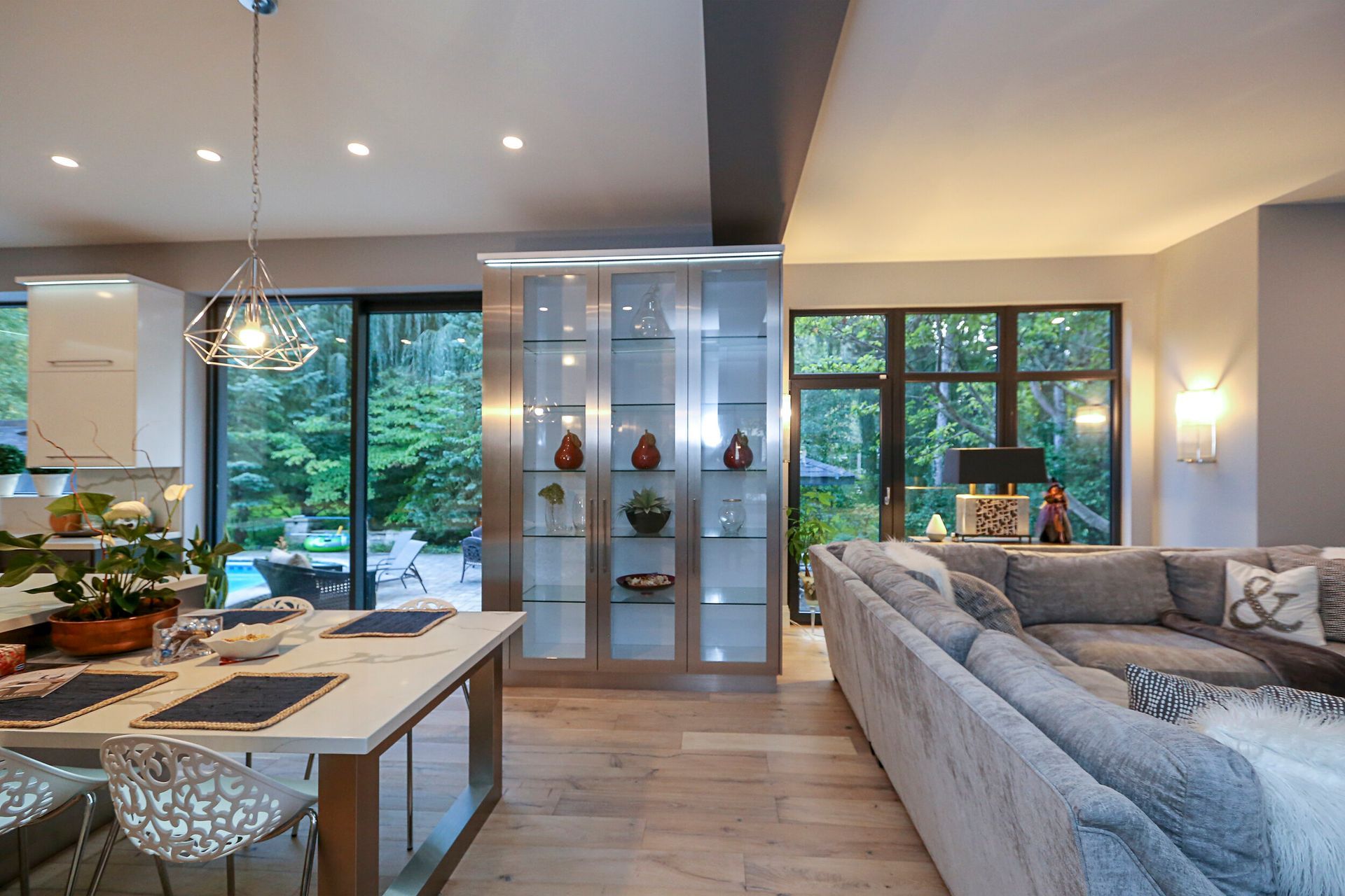 A living room with a large sectional couch and a dining table.
