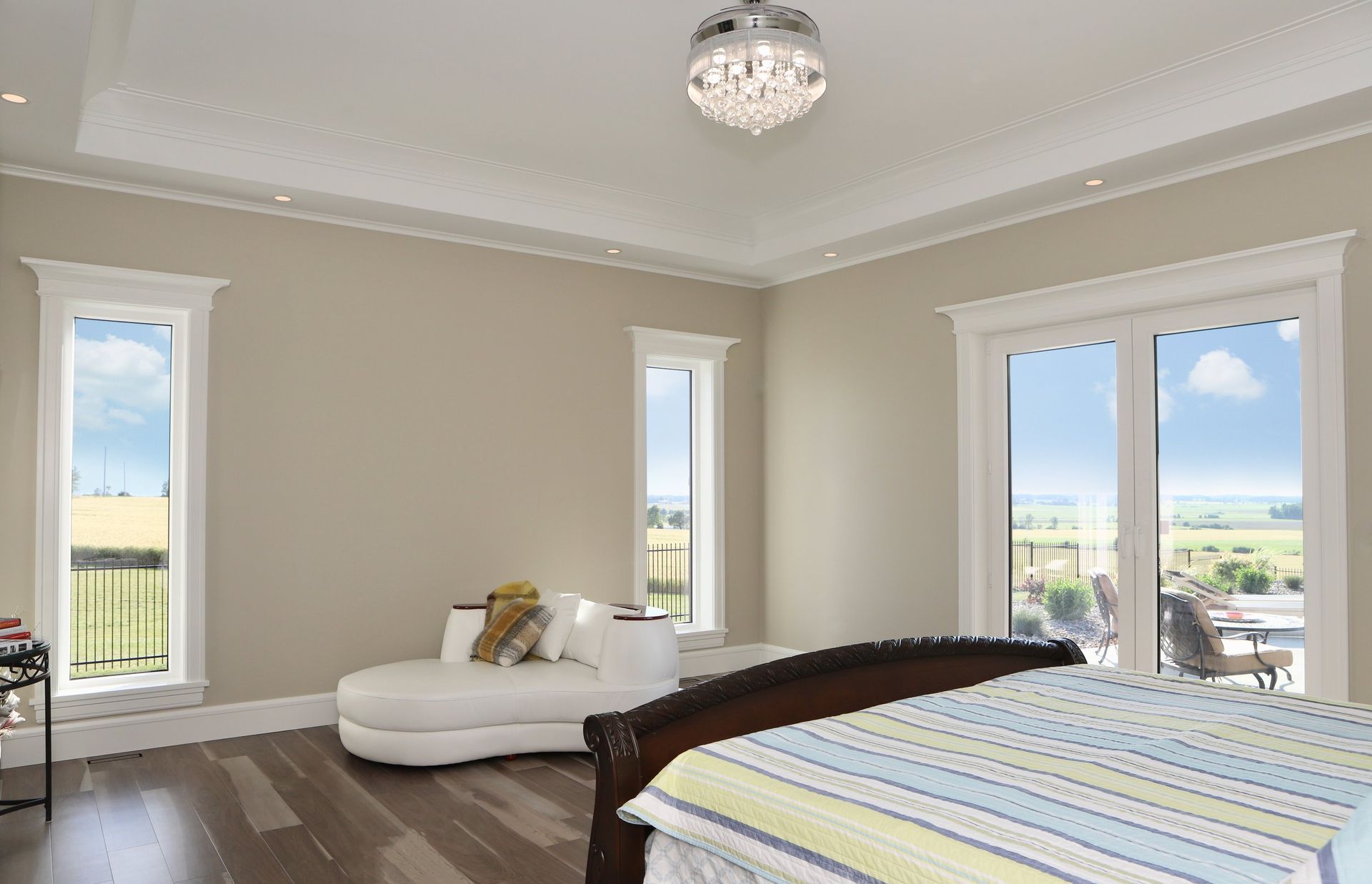 A bedroom with a bed , couch , and sliding glass doors.