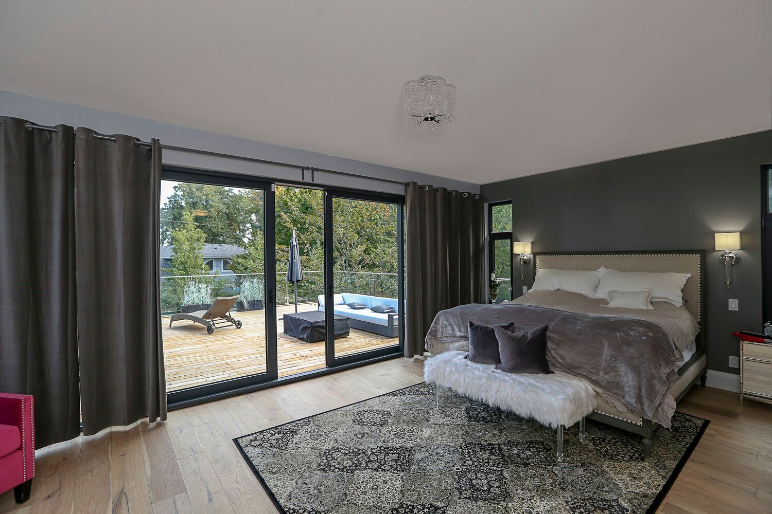 A bedroom with a large bed , sliding glass doors , and a rug.