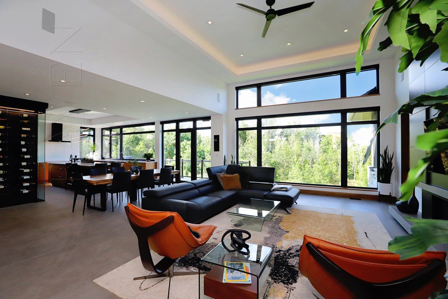 A living room with a lot of windows and a ceiling fan