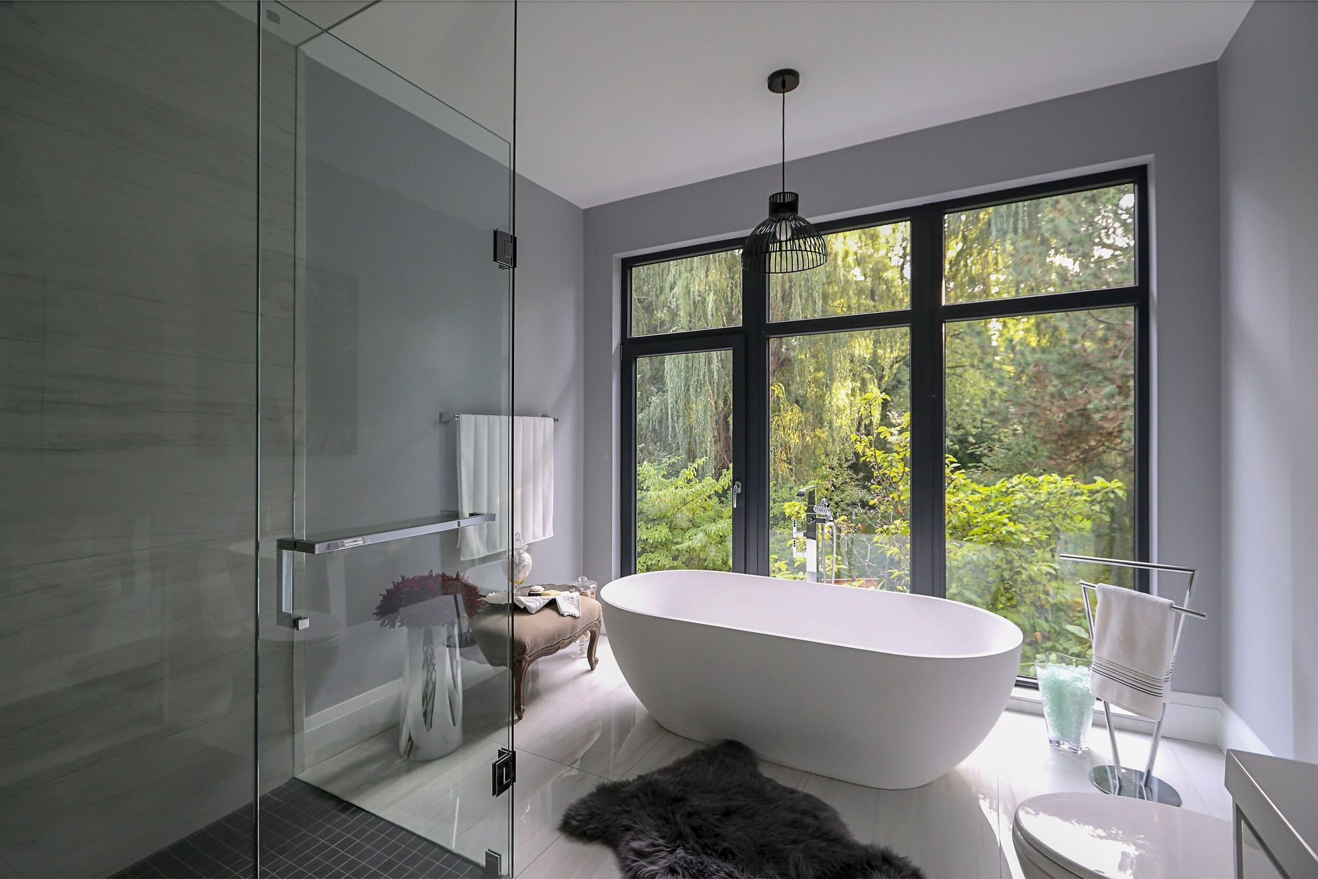 A bathroom with a bathtub and a large window.