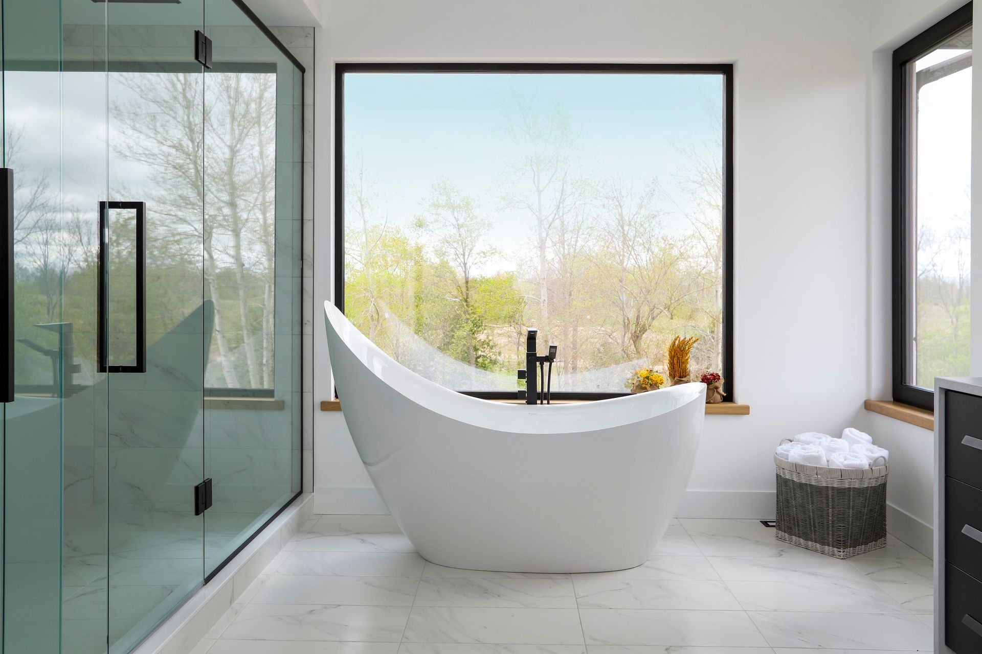 A bathroom with a bathtub and a large window.