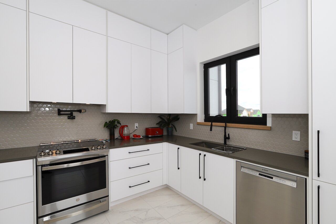 A kitchen with white cabinets and stainless steel appliances