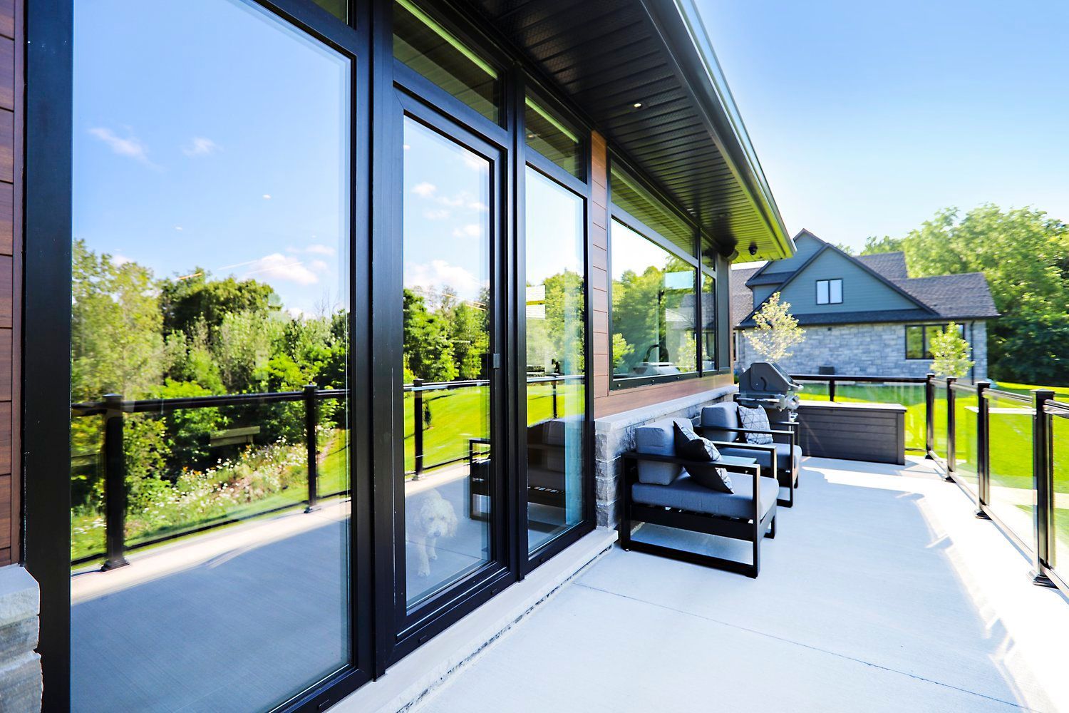 A large patio with a lot of windows and chairs.