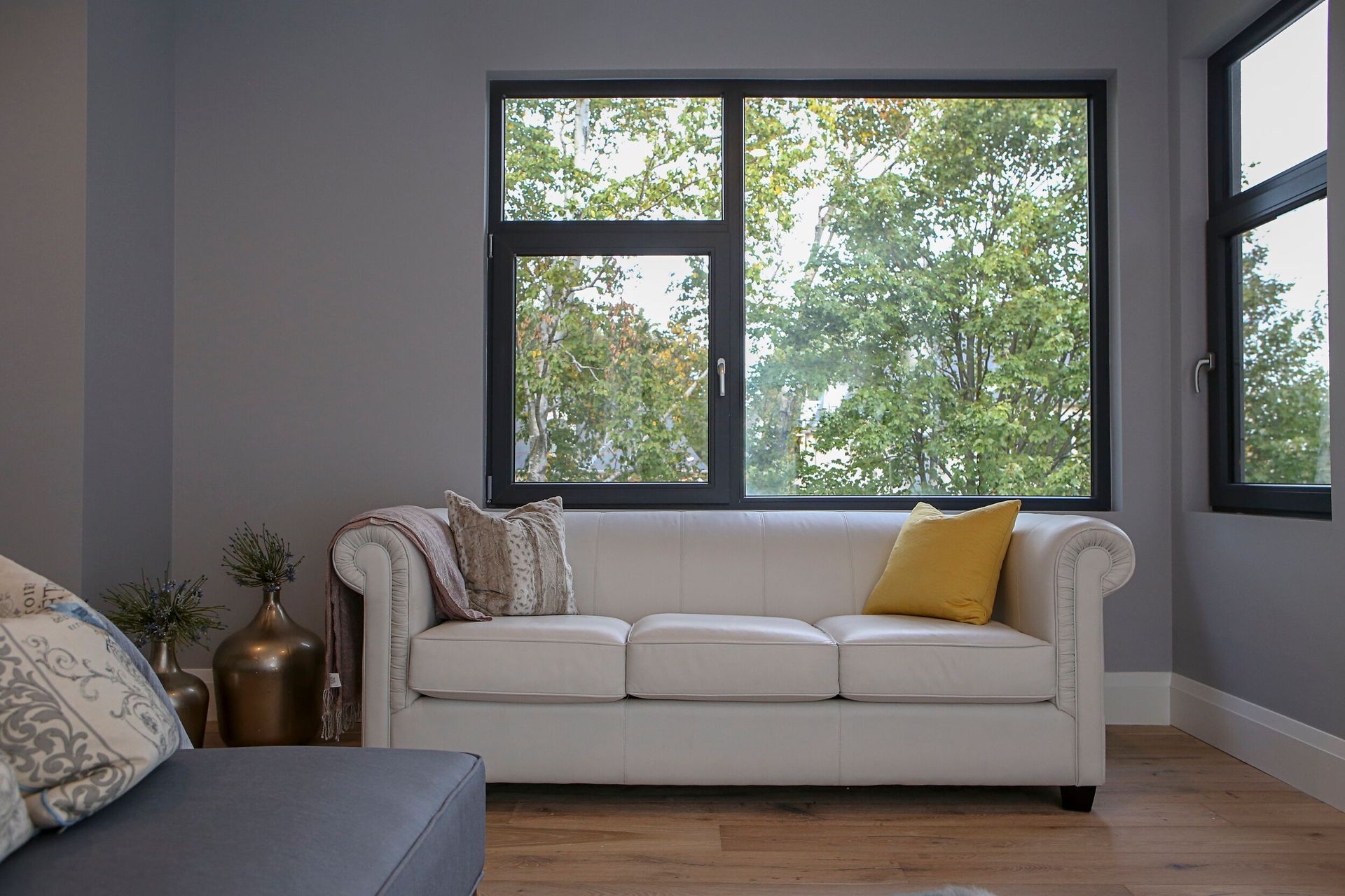 A living room with a white couch and a large window.