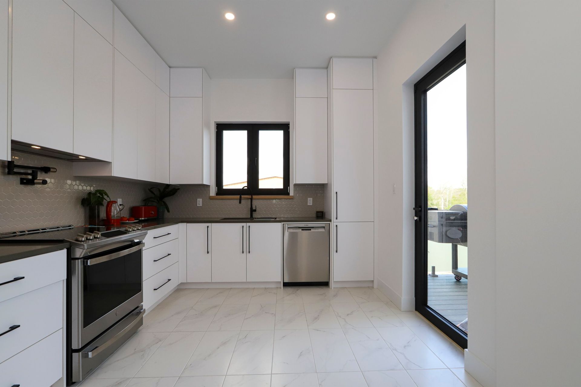 A kitchen with white cabinets and stainless steel appliances