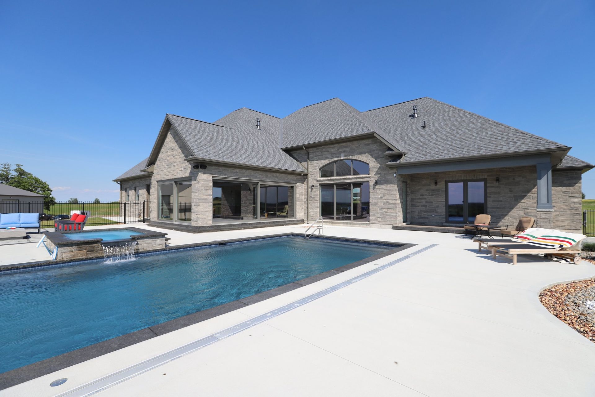 A large house with a large swimming pool in front of it.