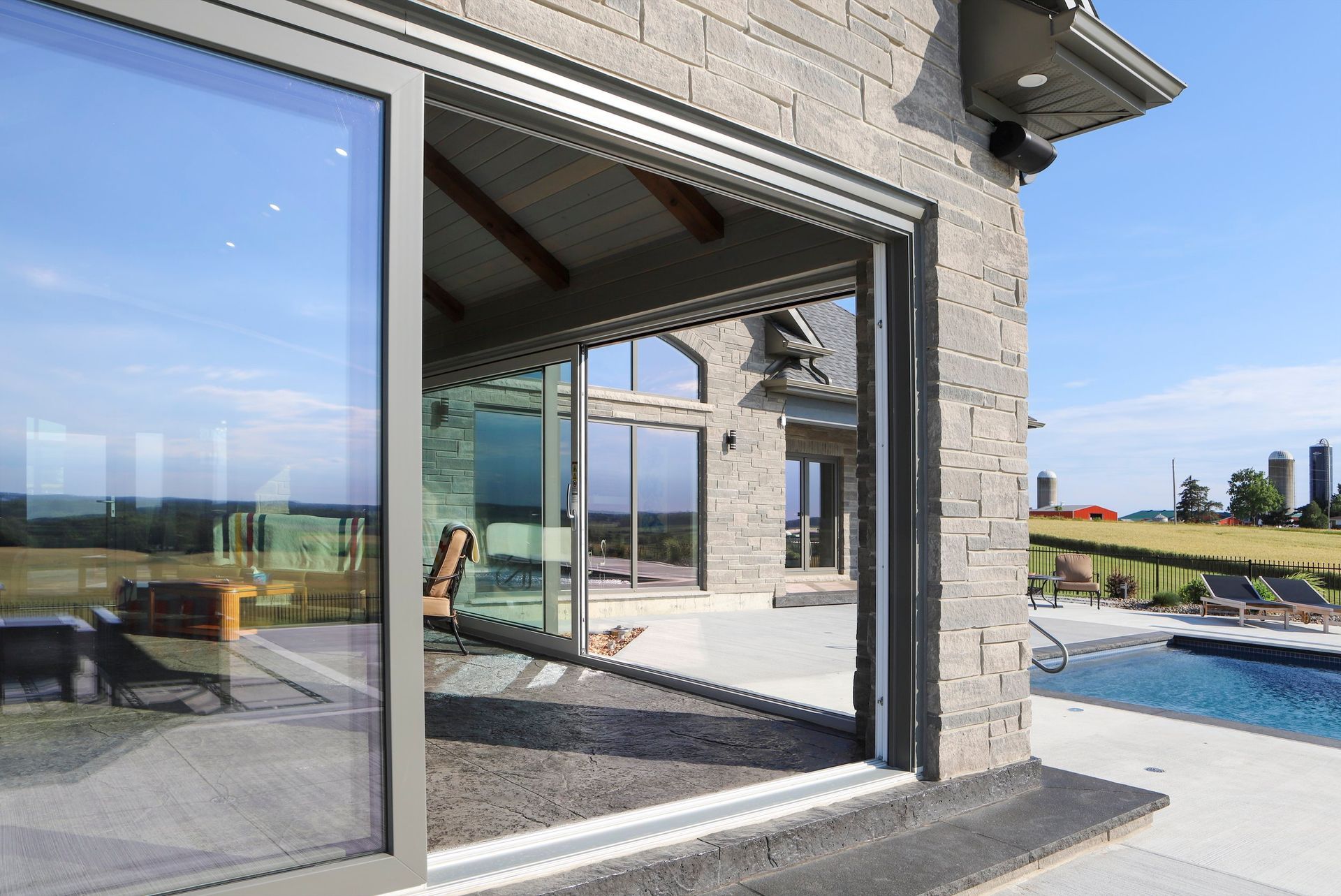 A house with a large sliding glass door leading to a pool.