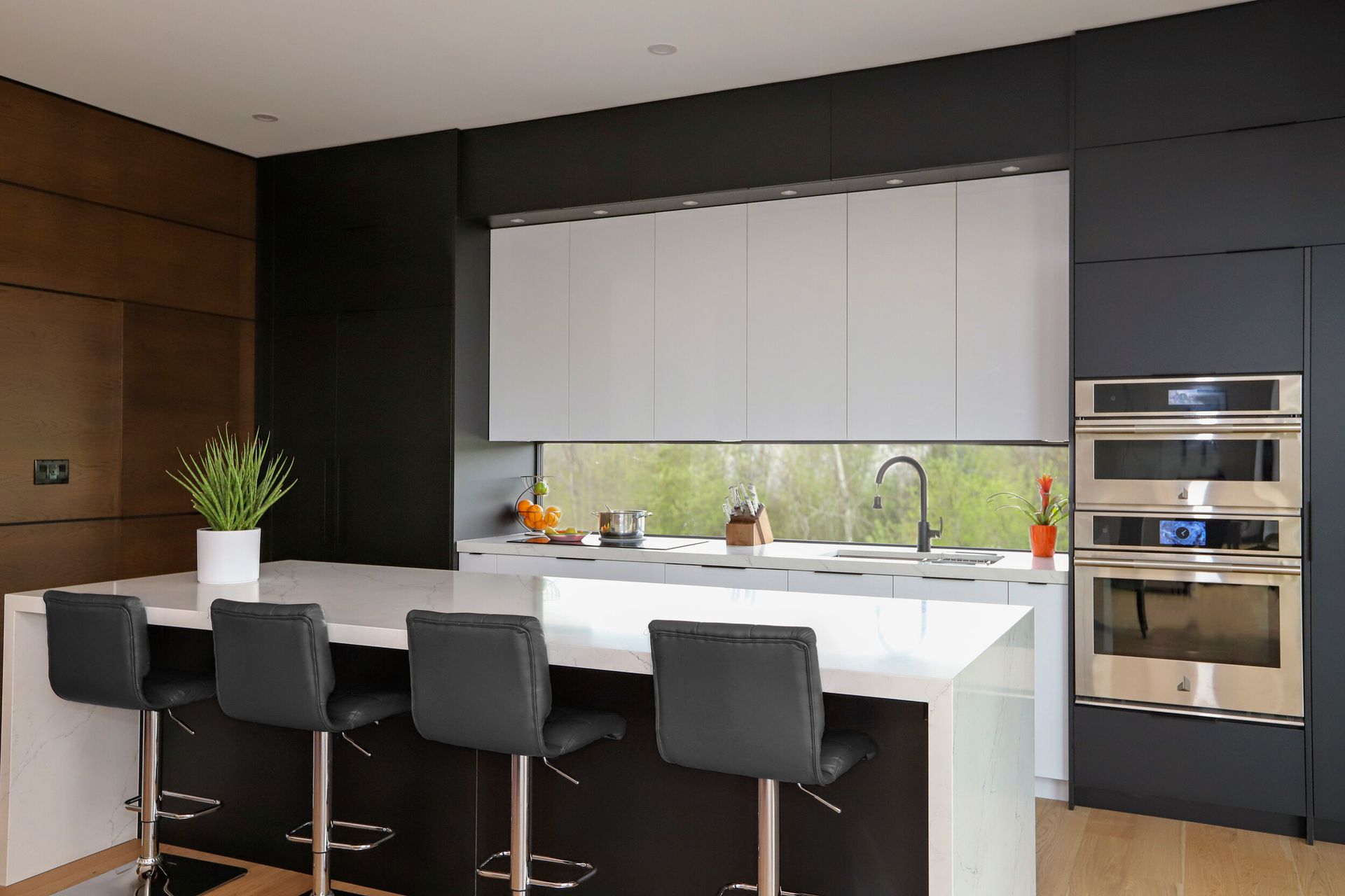 A kitchen with black and white cabinets and stainless steel appliances