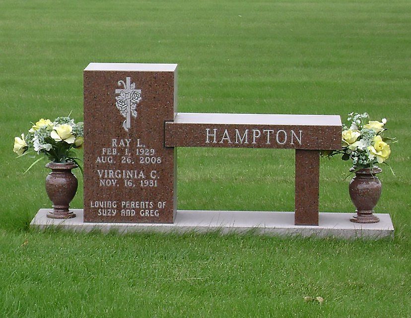 A gravestone for ray hampton with a bench and vases of flowers