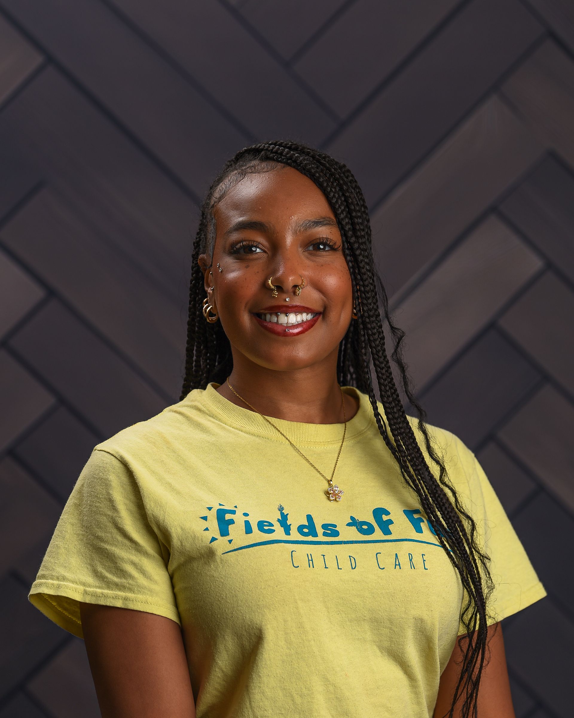 A woman wearing a red t-shirt is smiling for the camera.