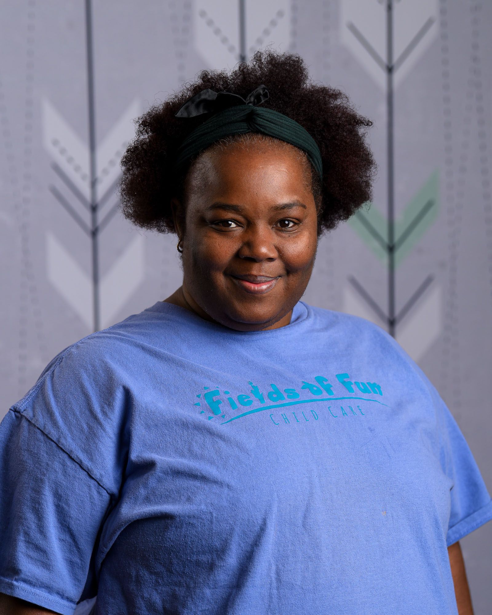 A woman with red hair is wearing a t-shirt that says fields of fun.