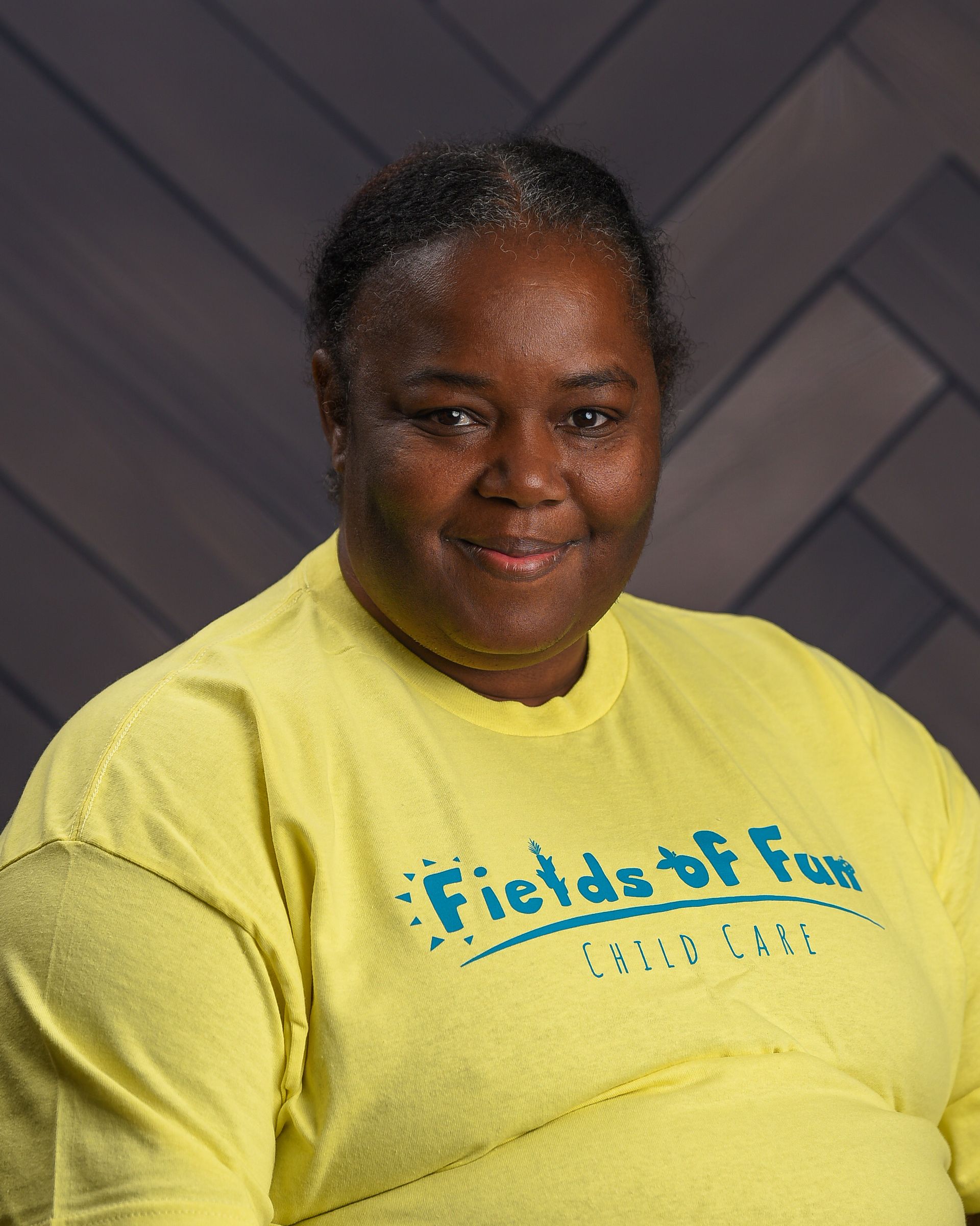 A woman with red hair is wearing a t-shirt that says fields of fun.