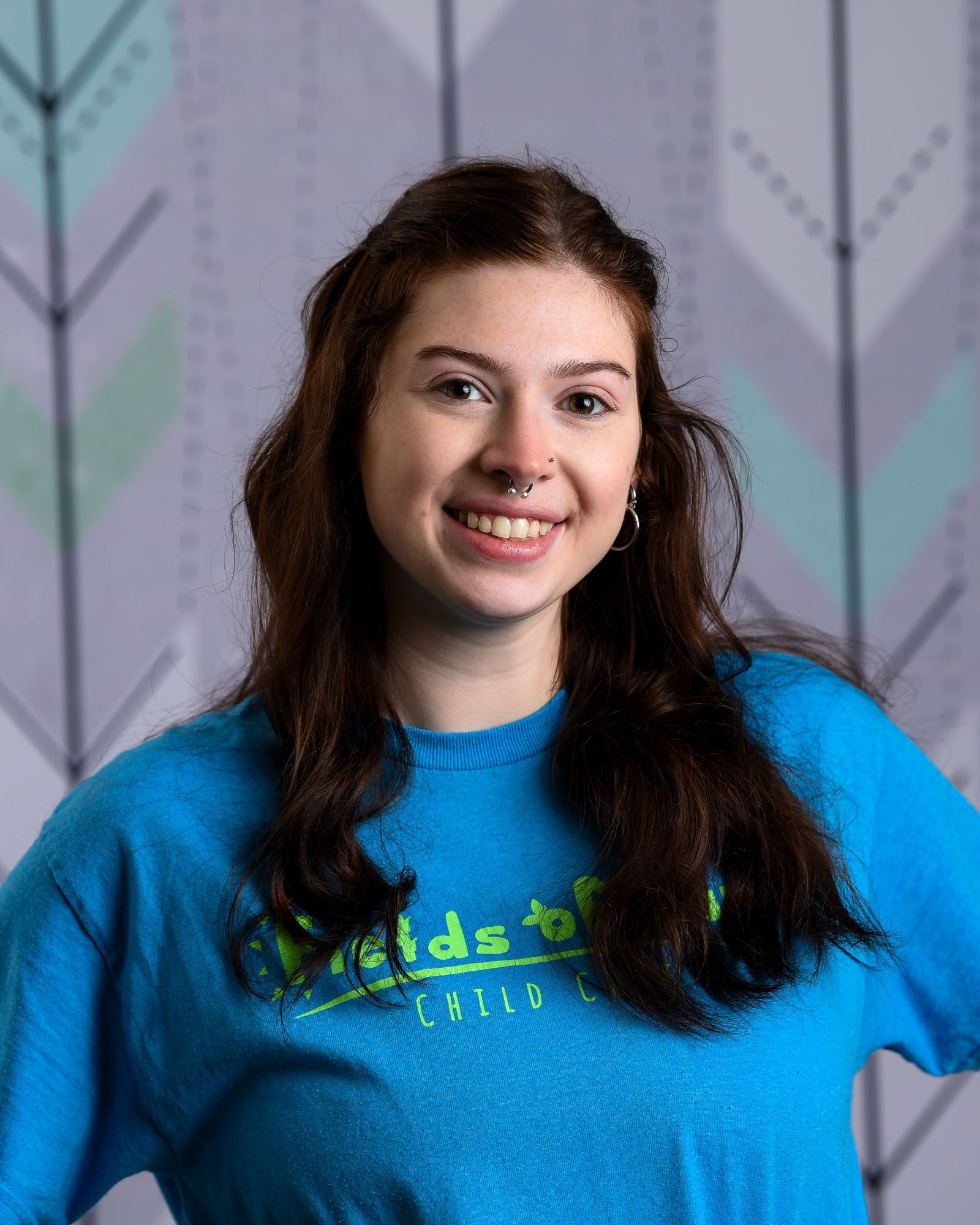 A woman with red hair is wearing a t-shirt that says fields of fun.
