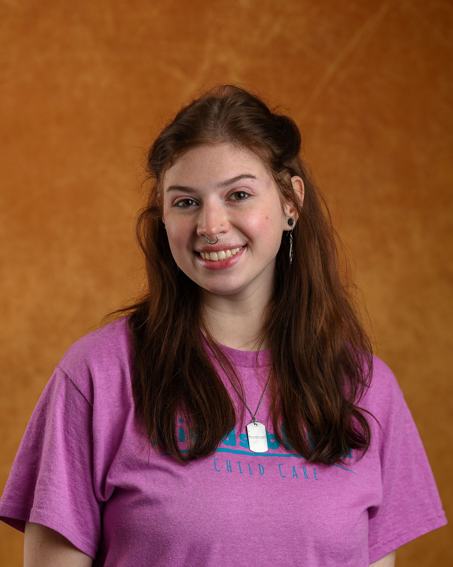 A woman with red hair is wearing a t-shirt that says fields of fun.