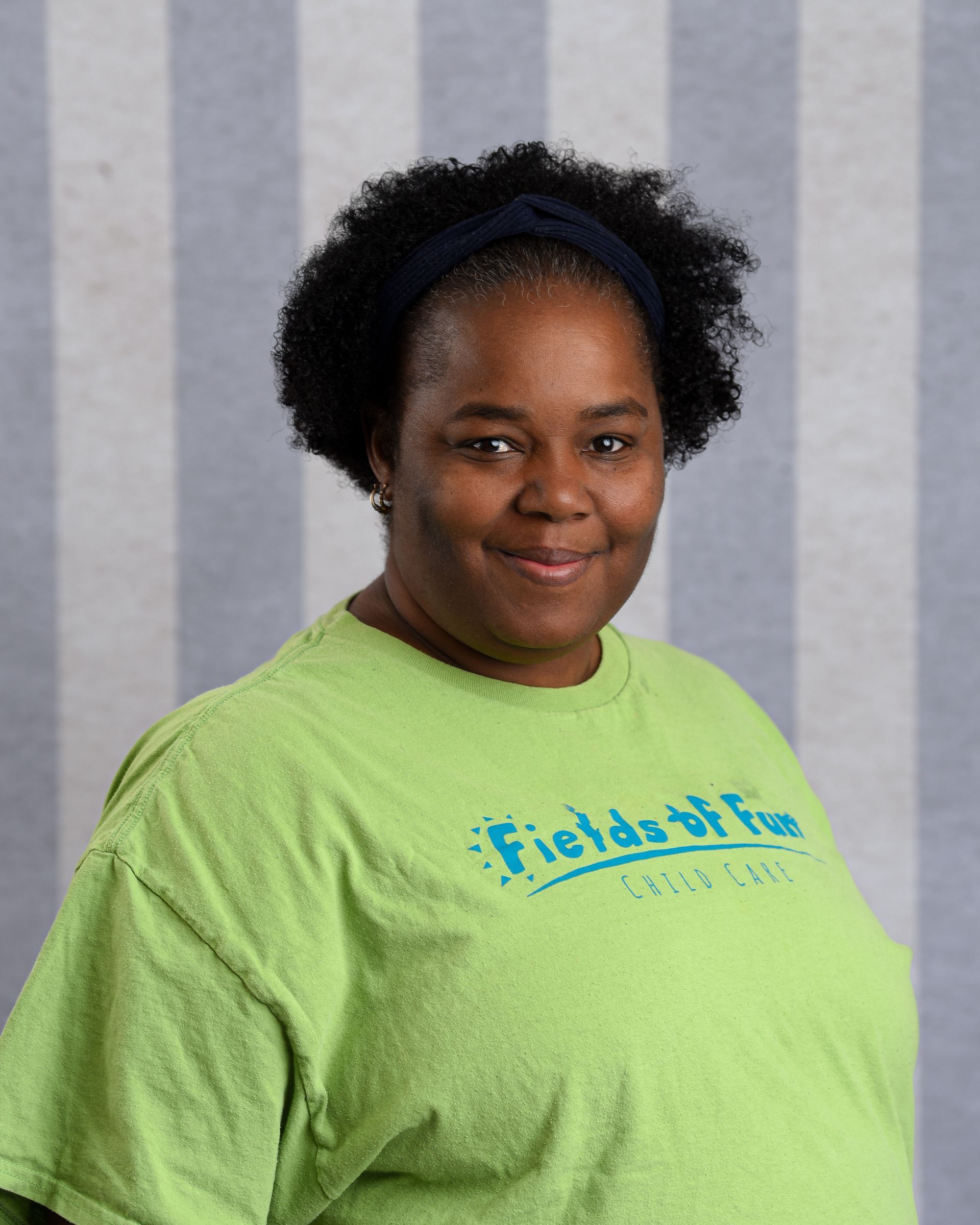 A woman with red hair is wearing a t-shirt that says fields of fun.