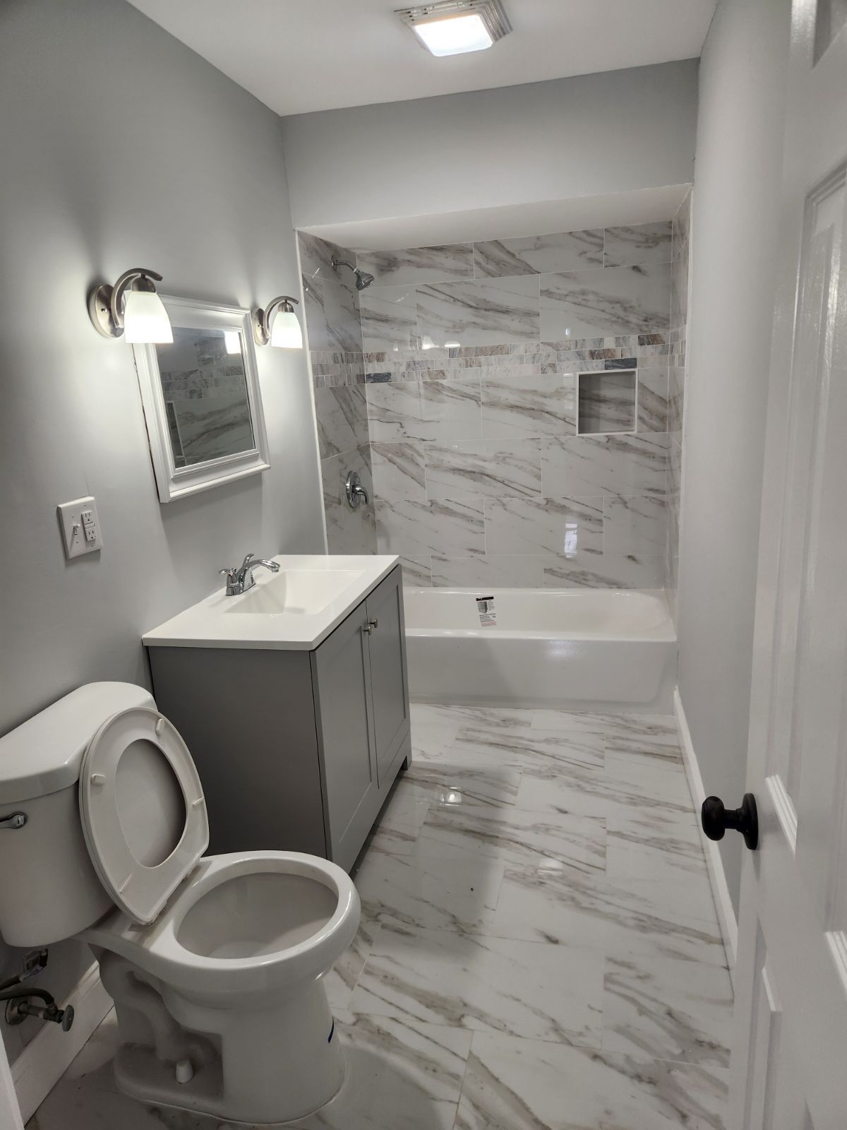 A bathroom with a toilet , sink , and bathtub.