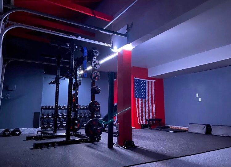 Modern gym with red pillars, weight equipment, and an American flag on the wall
