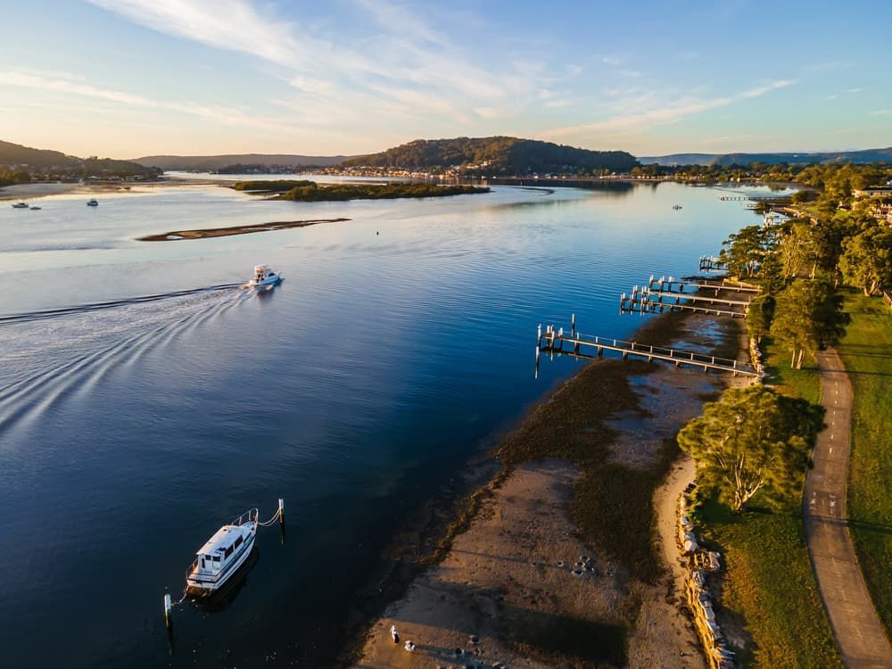 An Aerial View of A River with A Boat in The Water — Pest Control Central Coast in Woy Woy, NSW