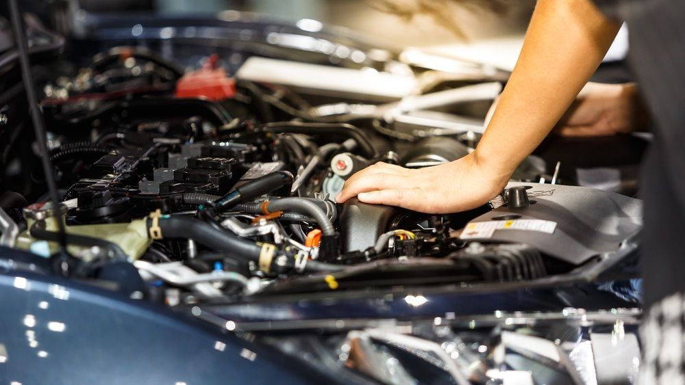 A Person Is Working On The Engine Of A Car — Mackay Car & Commercial Pty Ltd In Paget, QLD