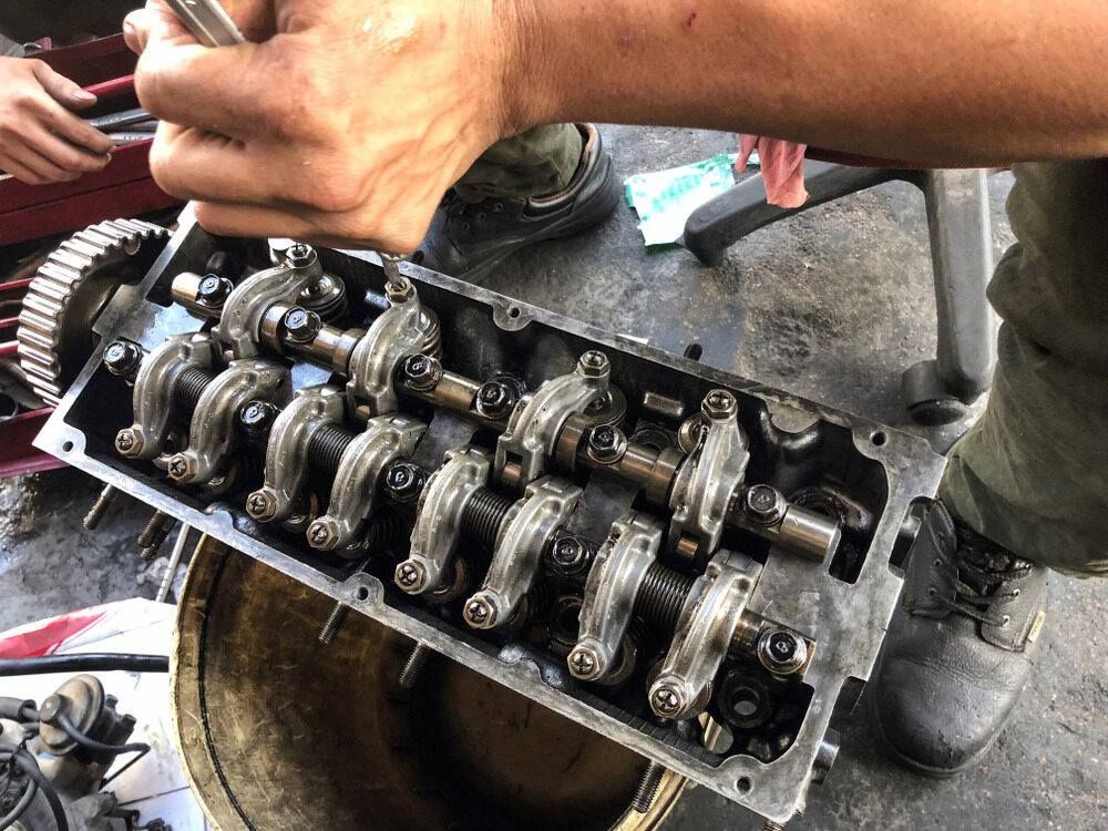 A Man Is Working On A Car Engine With A Wrench — Mackay Car & Commercial Pty Ltd In Paget, QLD
