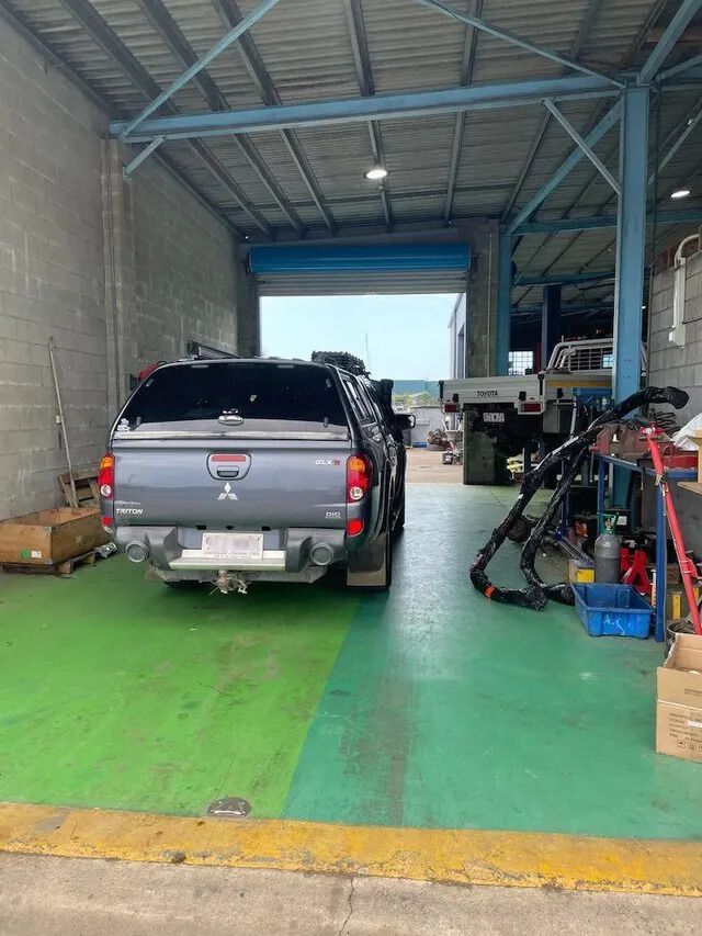 A Truck Is Parked In A Garage With A Green Floor — Mackay Car & Commercial Pty Ltd In Paget, QLD