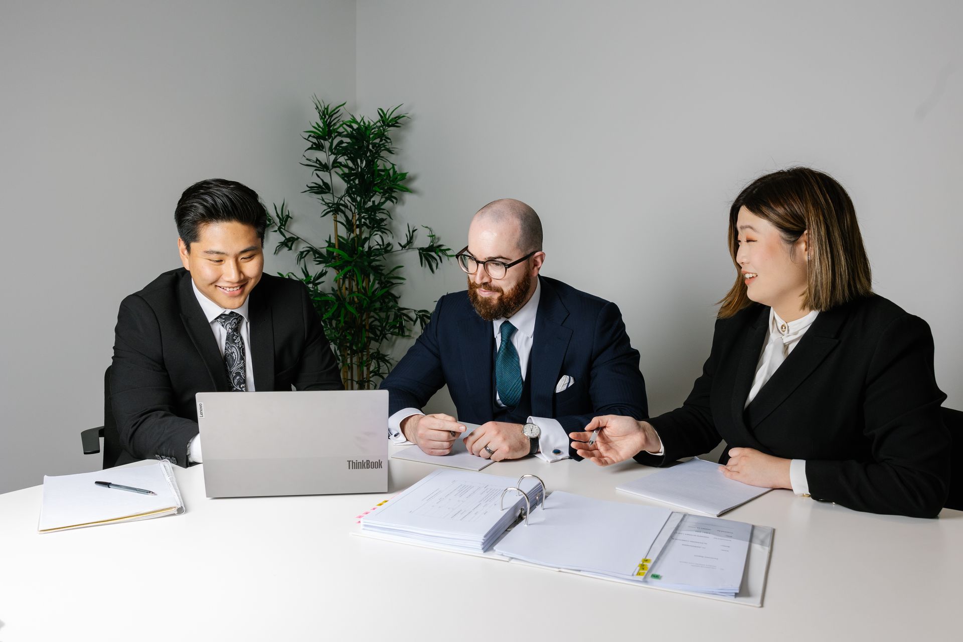 The team at Andrew Byrnes Law Group are sitting at a table looking at a laptop