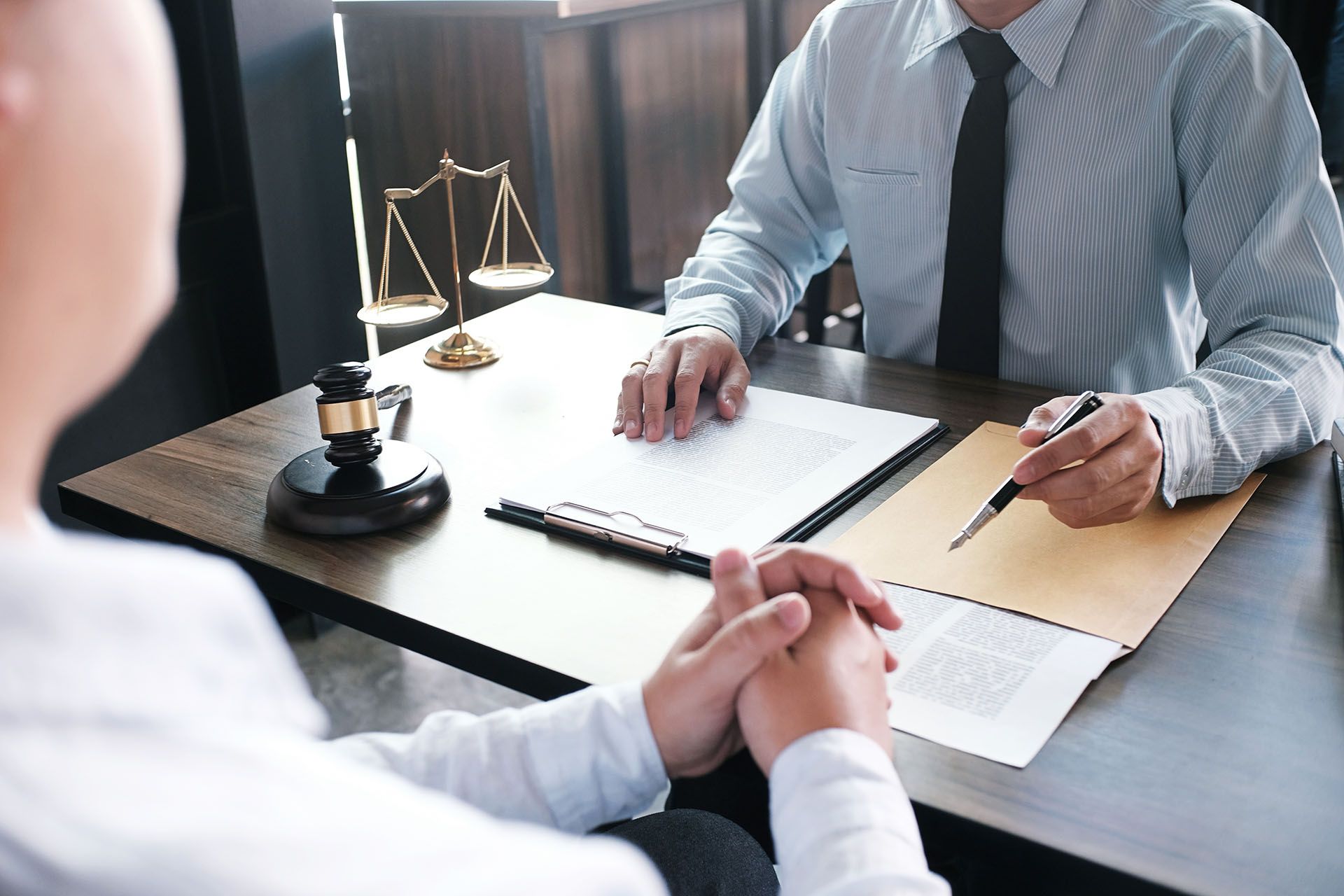 A lawyer is sitting at a table talking to a client.