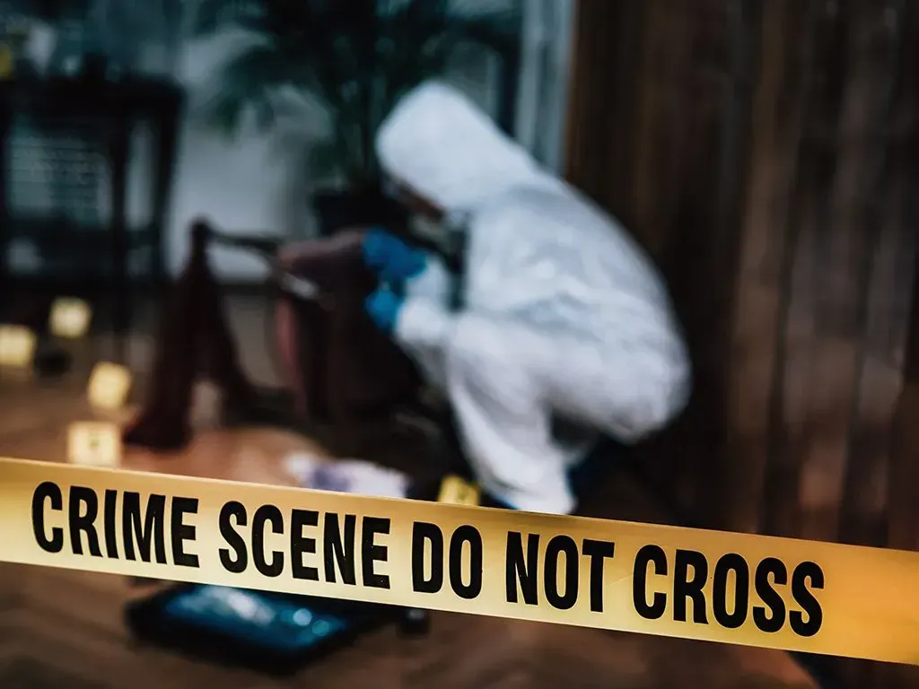 a crime scene do not cross tape with a person in the background