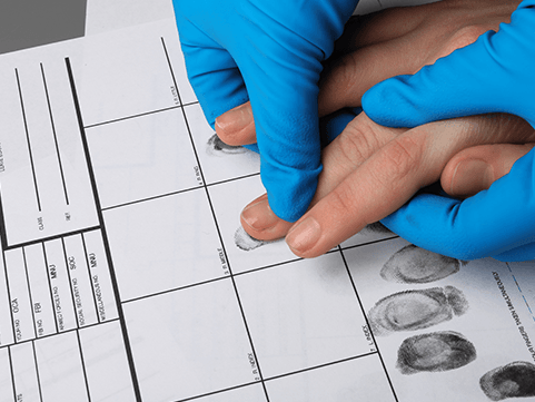 A person wearing blue gloves is taking a finger print