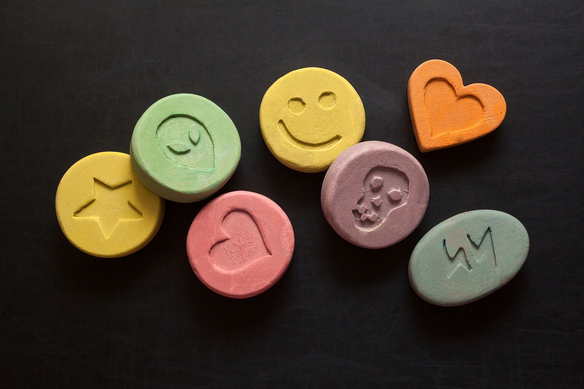 A bunch of candy with smiley faces and hearts on them