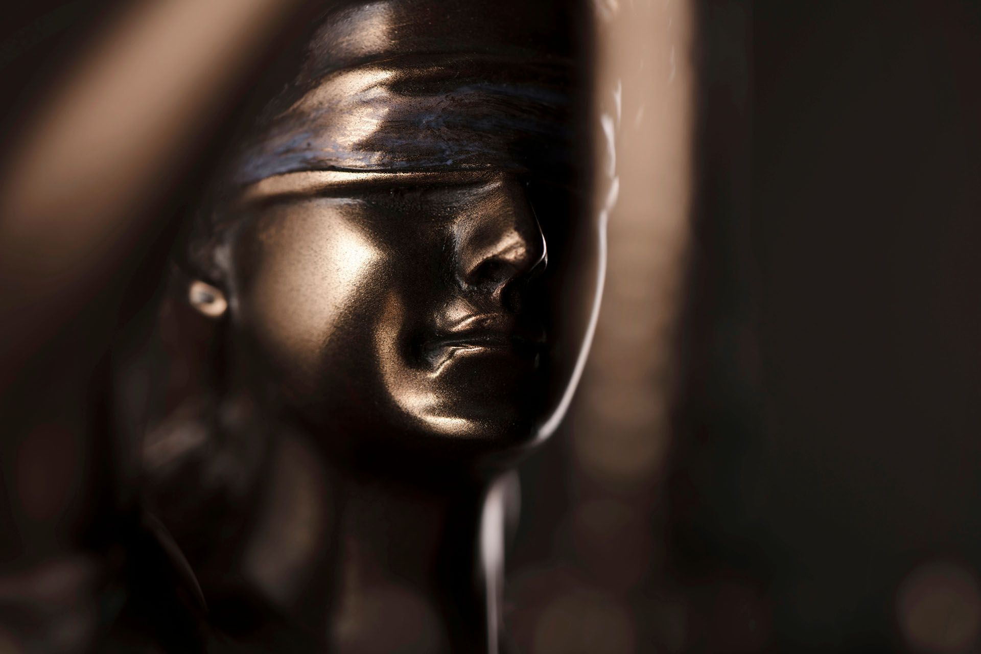 A close up of a statue of a woman with blindfolds on her eyes.