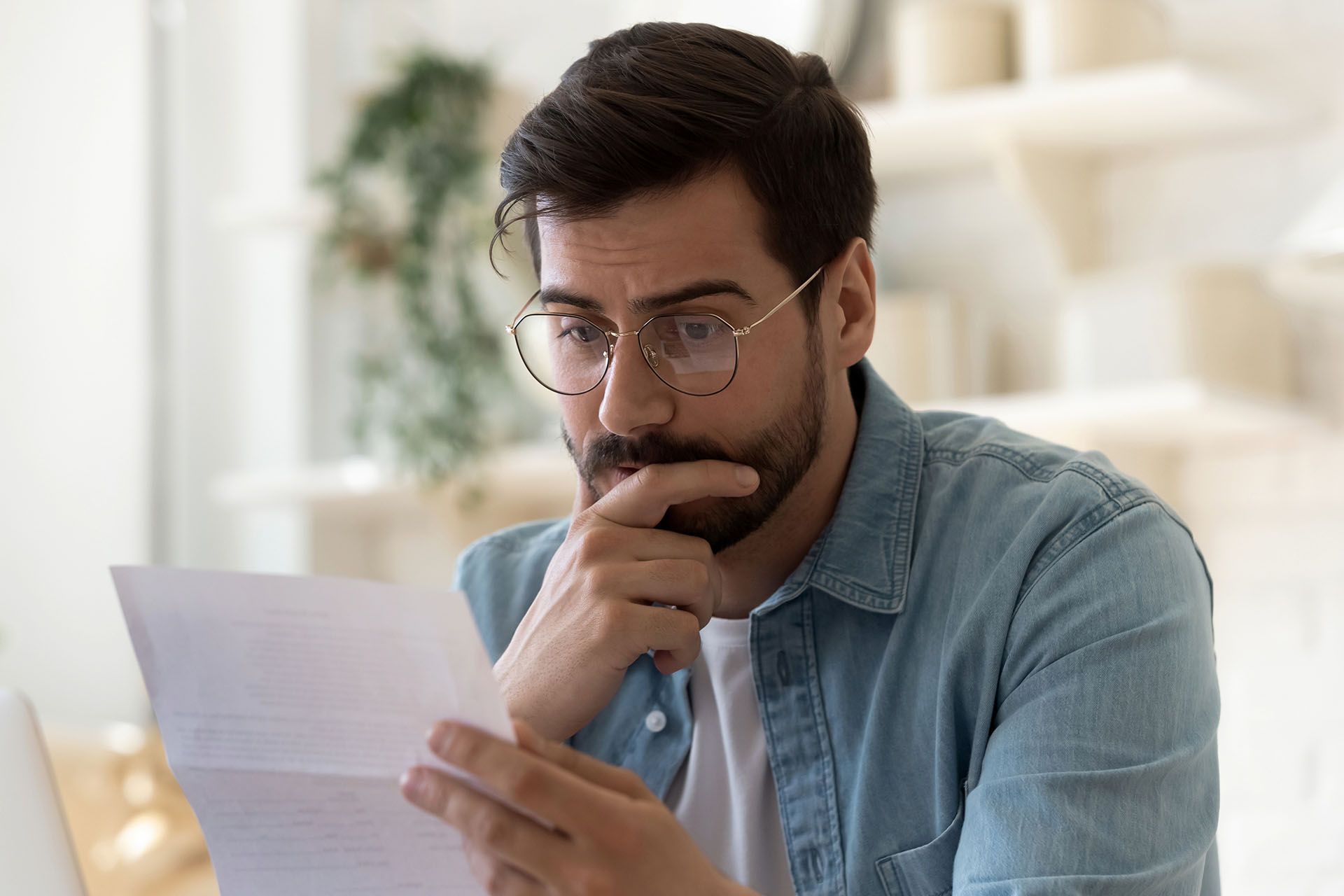 worried man looking at a piece of paper