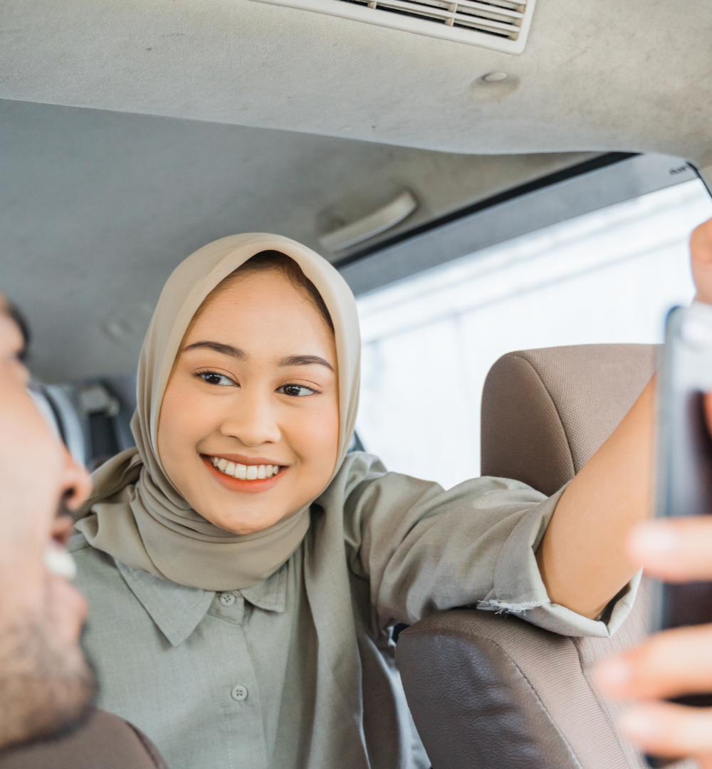 Father and child embrace in a car. The father smiles, wearing a striped shirt.