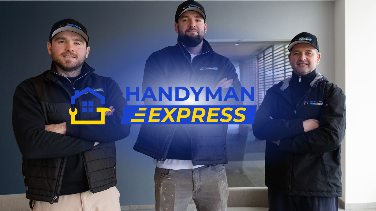 Three men in work gear posing behind a blue Handyman Express logo