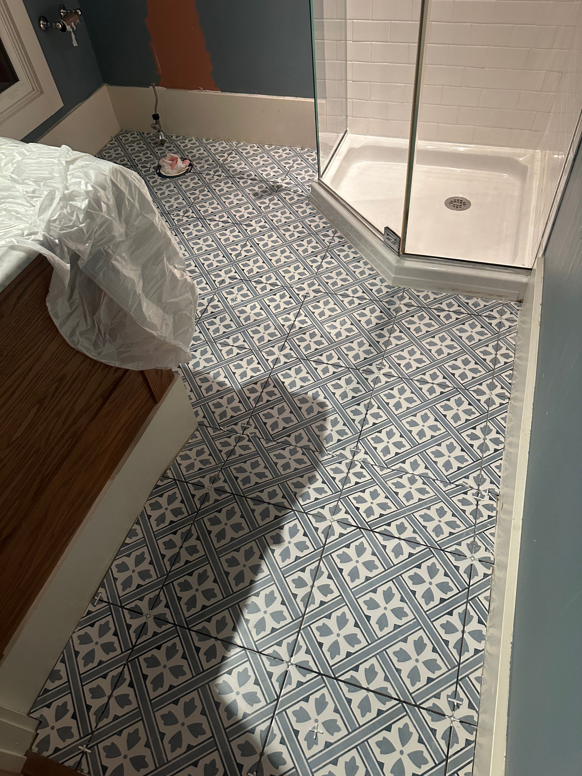 Long rectangular table, painted light gray, on a black metal base, in a garage. Paint supplies visible.