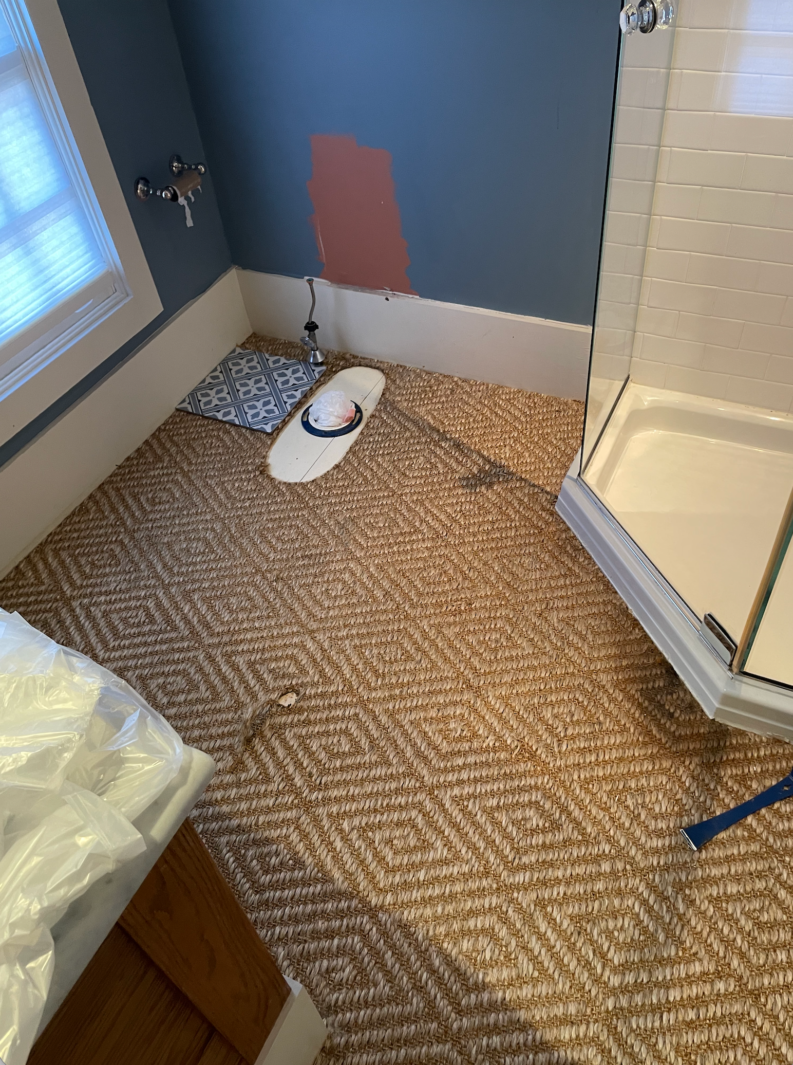 A rectangular wooden table on a white sheet in a garage, with a sander on it and tools below.