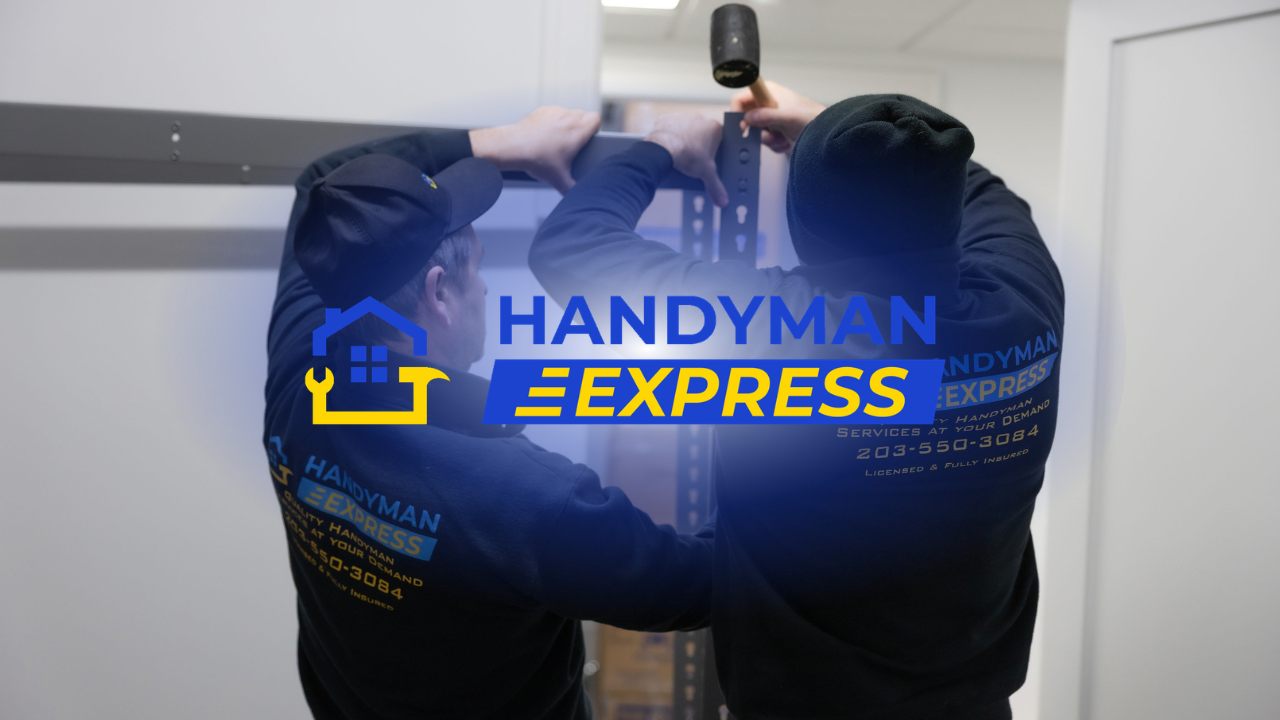 Handyman Express worker on a wooden deck, seen from behind near green hedges and railing.