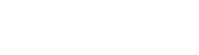 A person in a black coat and red scarf walks through a snow-covered park lined with bare trees.