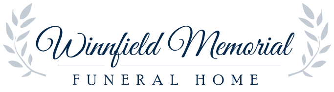 The logo for Winnfield Memorial Funeral Home, featuring elegant dark blue text framed by light grey laurel leaf branches.