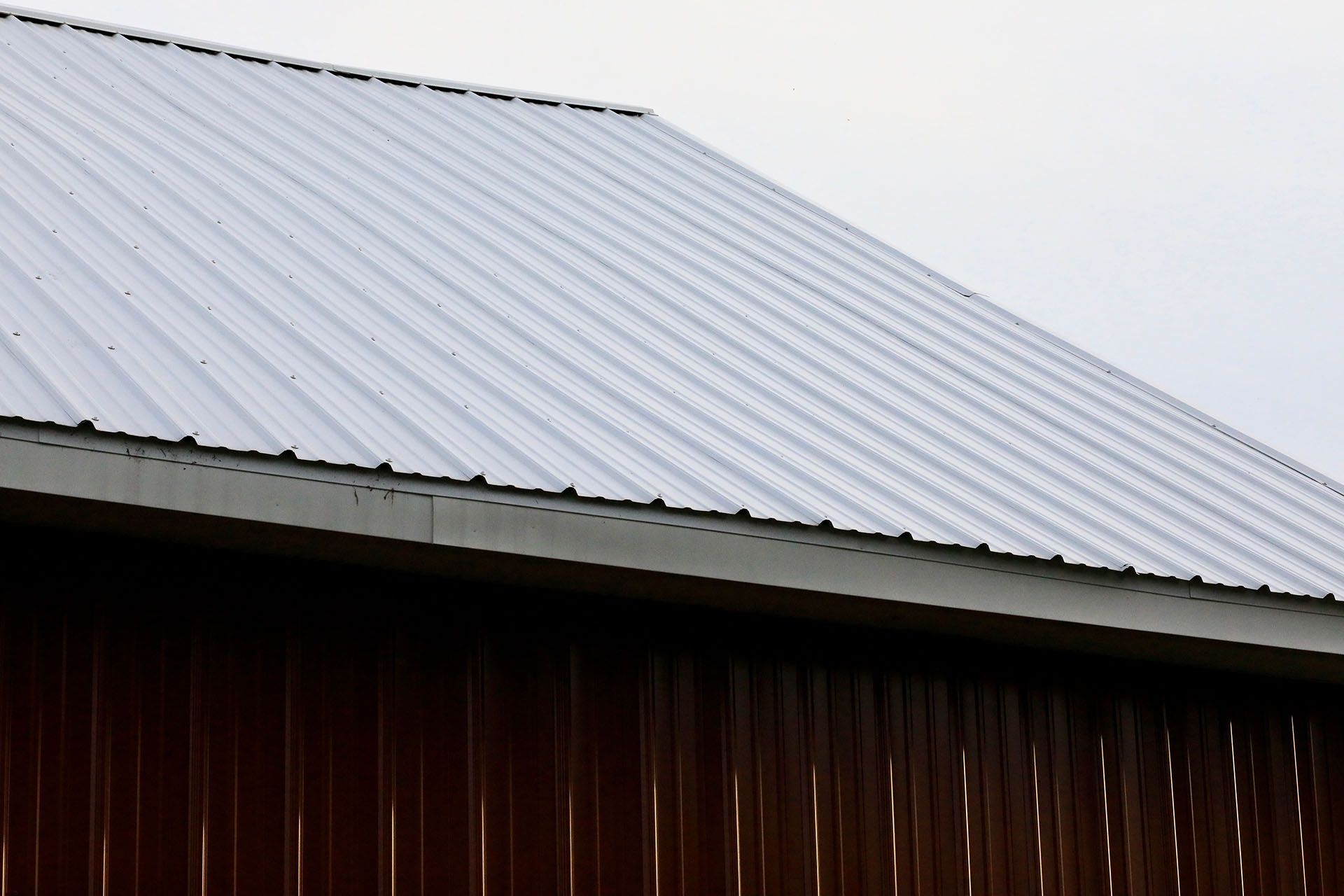 Red metal barn with a curved, corrugated metal roof