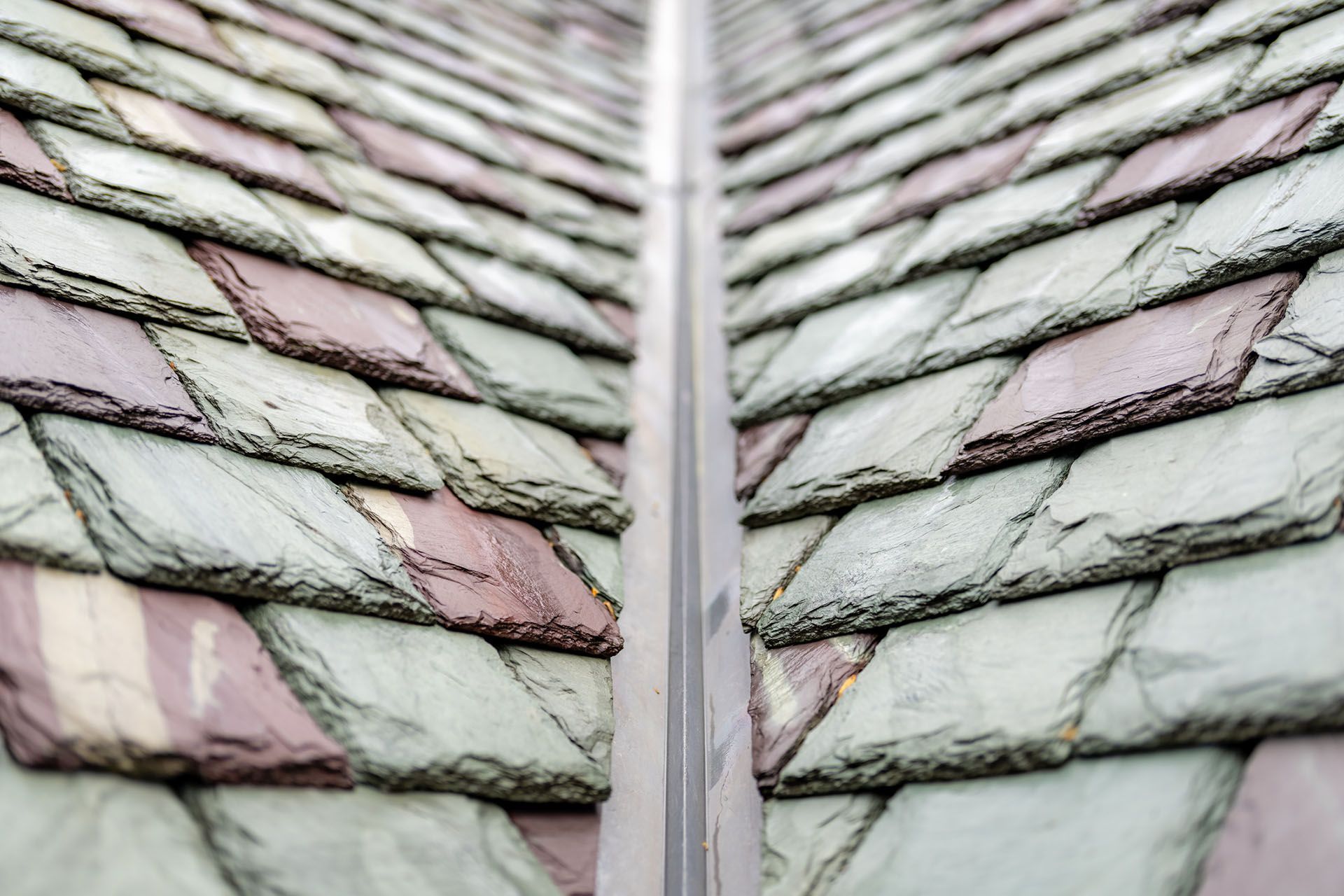 Roof with green and purple tiles, viewed from a central gutter